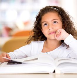 Thoughtful girl reading a book and using her imagination-1